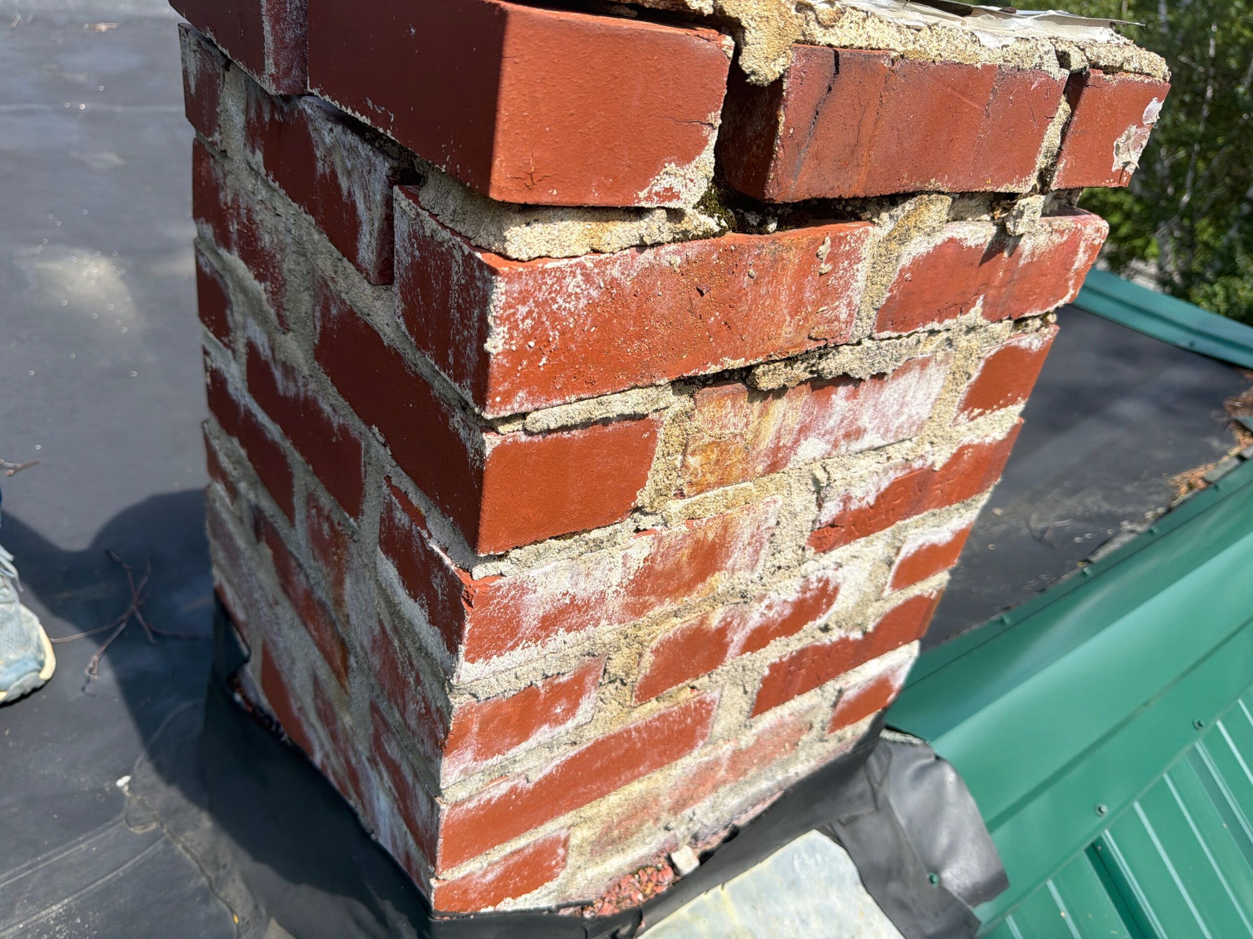 Damaged brick chimney with deteriorated mortar joints observed during a home inspection